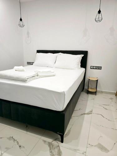 a bed with white sheets and white pillows on it at Philoxenia Guest Studio in Himare