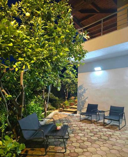 two chairs and a table under a tree at Philoxenia Guest Studio in Himare