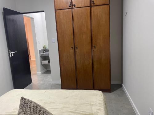 a bedroom with a large wooden cabinet next to a bed at Apartamento na Batista Campos 02 quartos in Belém
