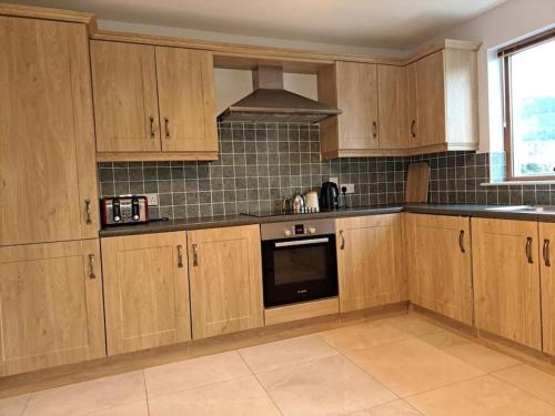 a kitchen with wooden cabinets and a stove top oven at Donard View, Newcastle in Newcastle