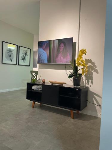 a living room with a tv on a wall at Apartamento na Batista Campos 02 quartos in Belém