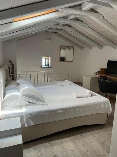 a large white bed in a room with a desk at Alika Resort in Álika