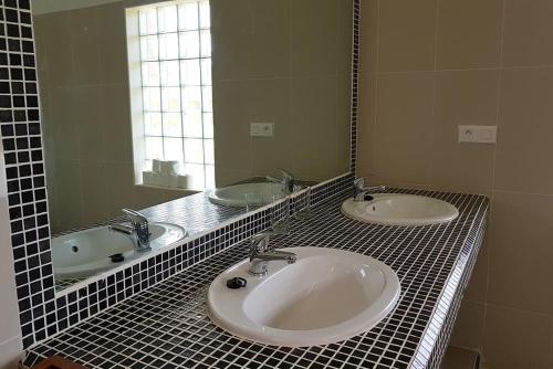 a bathroom with two sinks and a large mirror at Ocean Lodge Resort in Cap Skirring