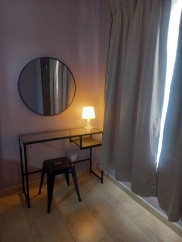 a table with a lamp and a mirror on a wall at Tambun Homestay in Tambun