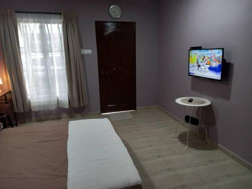 a living room with a couch and a flat screen tv at Tambun Homestay in Tambun