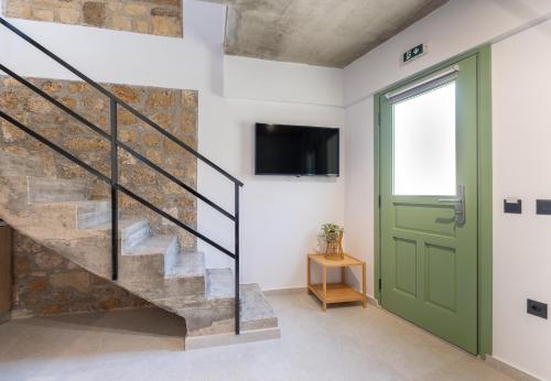 a staircase with a green door and a stone wall at Casa del Sol Suites in Rhodes Town