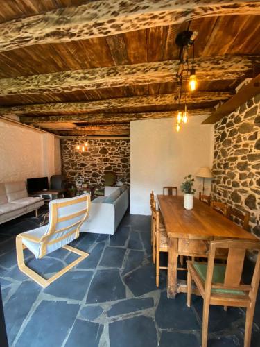 un salon avec une table et des chaises en bois dans l'établissement La maison des sables, à La Paute