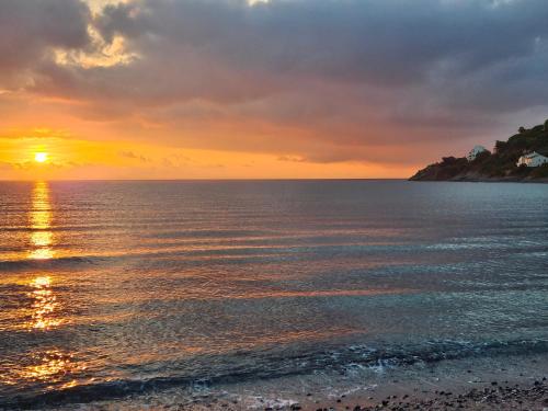 a sunset over the ocean with a beach at Maison Bella Vista in Cagnano