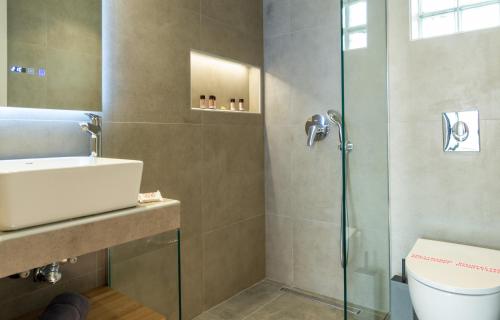 a bathroom with a shower and a sink and a toilet at Villa Linea Verde I by Sealand Villas in Tsilivi