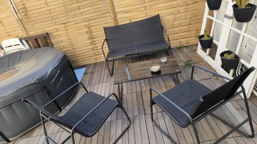 un patio con 2 sillas, una mesa y una tienda de campaña en Appartement, prive terrasse, parking et jardin, en Le Boulou