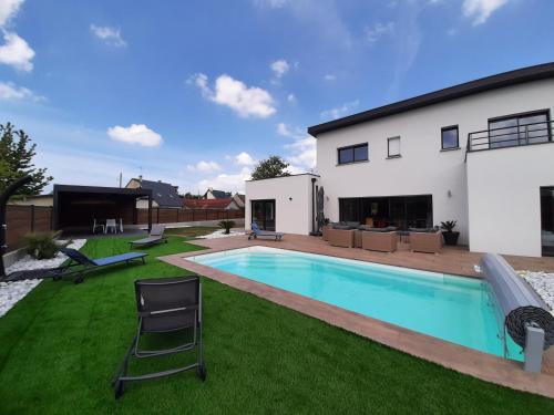 une cour arrière avec une piscine et une maison dans l'établissement Carpe Diem, à Jullouville