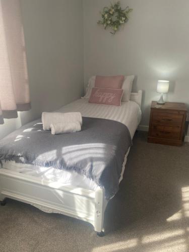 a bed with a pink pillow on it in a bedroom at The White Hart Apartment Valley View in Alton