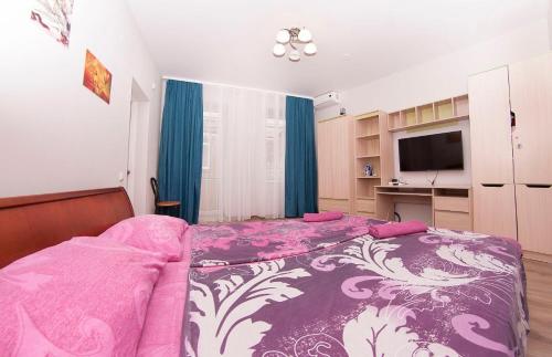 a bedroom with a bed with a purple and white blanket at apartments on Chkalova in Dnipro