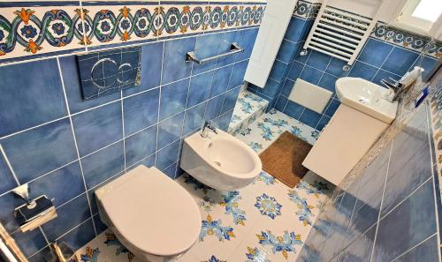 a blue tiled bathroom with a toilet and a sink at Relais Amalfi Coast in Conca dei Marini