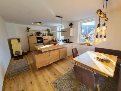 a kitchen with a table and a dining room at Apartment Neuwirthof - rustikaler Charme in Sankt Georgen ob Murau