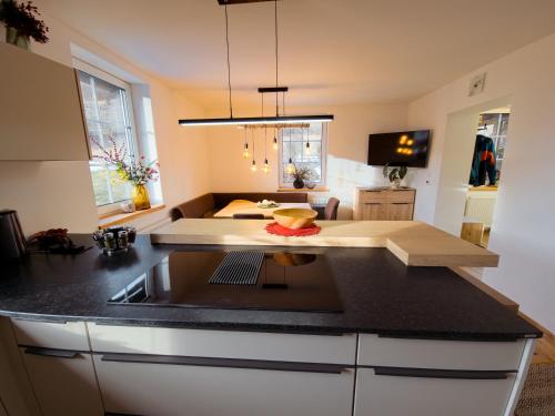 a kitchen with a counter top and a living room at Apartment Neuwirthof - rustikaler Charme in Sankt Georgen ob Murau