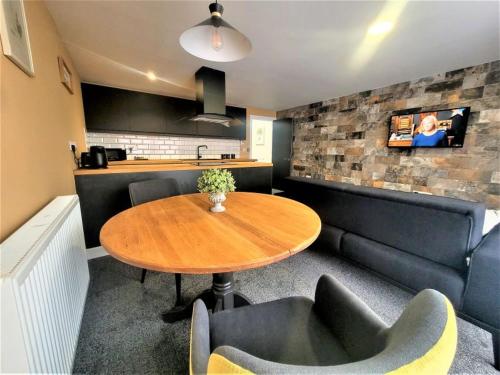 a room with a table and chairs and a kitchen at Friary House Serviced Apartments by Roomsbooked - 24Hr Reception in Gloucester