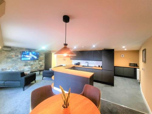 a kitchen and living room with a table and a couch at Friary House Serviced Apartments by Roomsbooked - 24Hr Reception in Gloucester