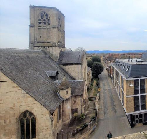 an old building with a tower and a church at Friary House Serviced Apartments by Roomsbooked - 24Hr Reception in Gloucester