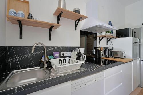 Il comprend une cuisine équipée d'un évier et d'un séchoir à vaisselle. dans l'établissement Lino - Terrasse - AC Clim - Wi-Fi, à Avignon