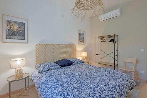 une chambre avec un lit avec une couette bleue dans l'établissement Lino - Terrasse - AC Clim - Wi-Fi, à Avignon