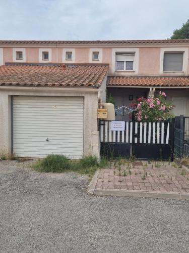 a house with a garage and a fence at Un Brin de Mistral in Saint-Louis-du-Rhône