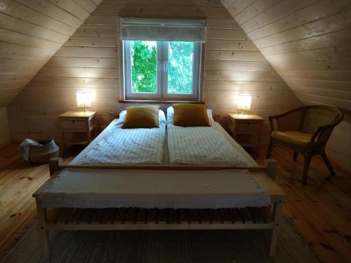 ein großes Bett in einem Zimmer mit Fenster in der Unterkunft Domek nad Czarną Hańczą - Przystań Kajakowa Zakole in Krasnopol