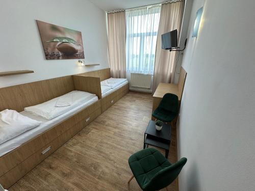 a hotel room with two beds and a chair at Penzion Raketa Bowling in Opava