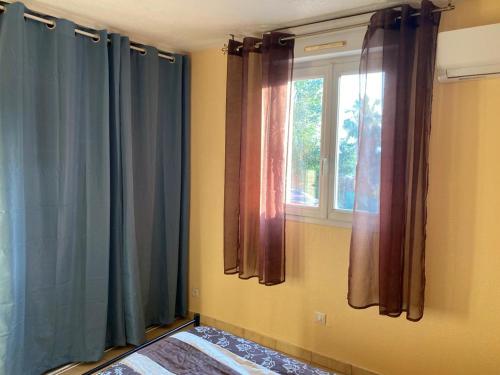 Cette chambre dispose d'une fenêtre avec des rideaux et d'un lit. dans l'établissement appartement Canet en Roussillon Malibu village, à Canet