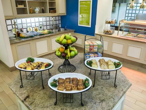 Hilton Garden Inn Washington DC/Greenbelt في غرينبيلت: ثلاثة أطباق من أنواع مختلفة من الطعام على المنضدة