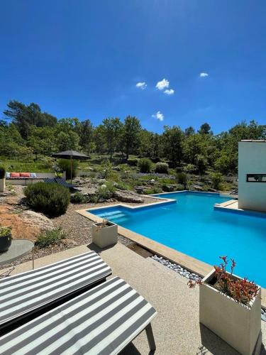 une grande piscine bleue avec un banc à côté dans l'établissement Villa Agave, à Camps-la-Source
