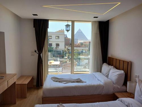 um quarto de hotel com duas camas e uma grande janela em Diamond pyramids hotel em Cairo