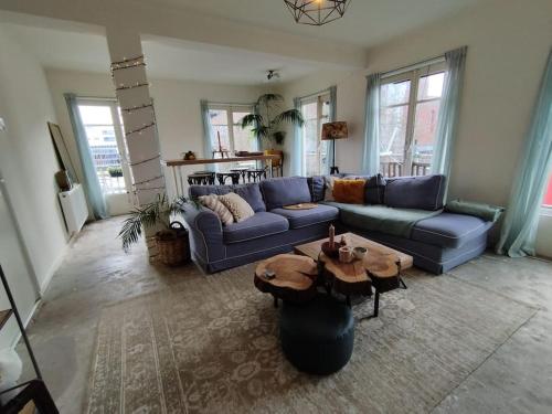a living room with a blue couch and a table at Penthouse in hartje Enschede in Enschede