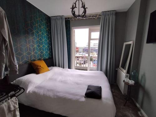 a bedroom with a large bed and a window at Penthouse in hartje Enschede in Enschede