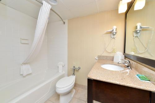a bathroom with a sink and a toilet and a bath tub at Hawthorne Inn & Conference Center in Winston-Salem