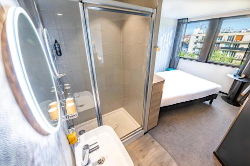 La salle de bains est pourvue d'une douche et d'un lavabo. dans l'établissement ibis Styles Paris 16 Boulogne, à Paris