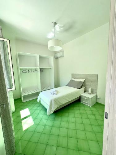 a bedroom with a bed and a green tiled floor at Simona House in Ravello