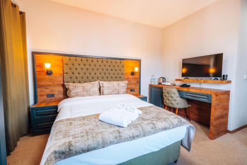 a bedroom with a bed and a desk and a sink at Mysia Olympos Hotel in Bursa