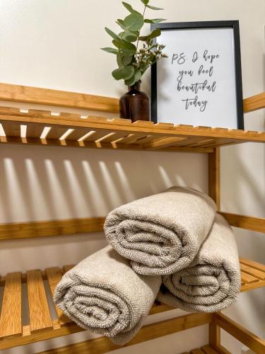 a couple of towels on a wooden shelf at Minimalistic apartment in Crystal Palace in Crystal Palace