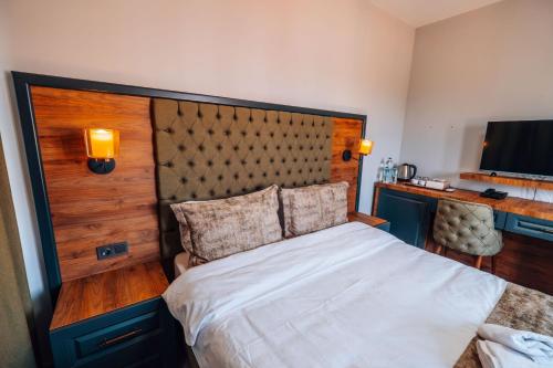 a bedroom with a large bed and a desk at Mysia Olympos Hotel in Bursa
