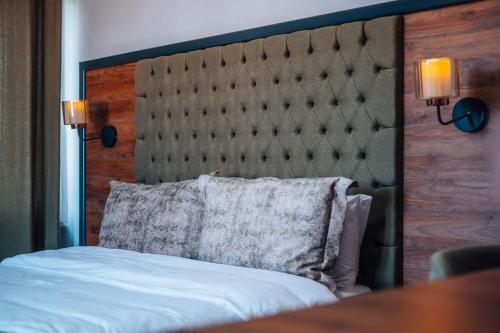 a bed with a large headboard and a pillow at Mysia Olympos Hotel in Bursa