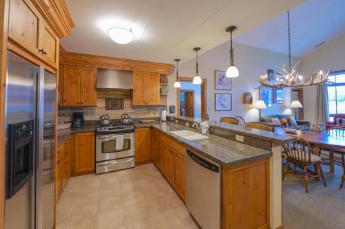 a kitchen with wooden cabinets and stainless steel appliances at The Lodge at Mountaineer Square in Mount Crested Butte