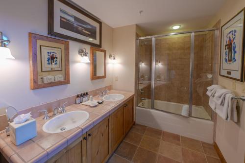 a bathroom with two sinks and a shower at The Lodge at Mountaineer Square in Mount Crested Butte
