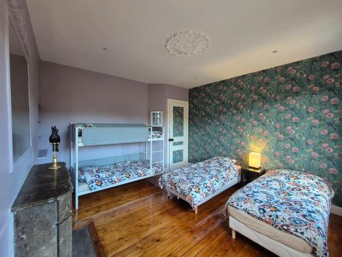1 Schlafzimmer mit 2 Betten und einer Wand mit Blumentapete in der Unterkunft Hotel particulier 200m2 plein centre et plage - 2 à 25 personnes in Dieppe