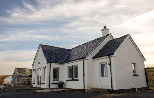 a white house with a black roof at Solas Alainn in Staffin