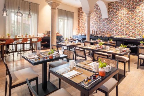 - un restaurant avec des tables et des chaises dans une salle dans l'établissement Eurostars Sevilla Boutique, à Séville