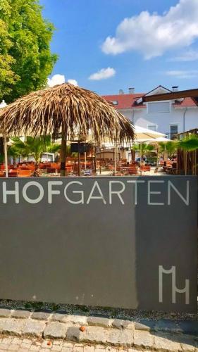 a restaurant with a straw umbrella and a sign at Mettner Hof in Metten