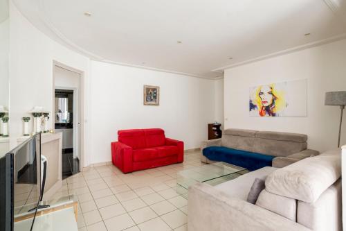 - un salon avec un canapé et un fauteuil rouge dans l'établissement Champs-Élysées Lincoln - 2BDR, à Paris