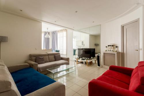 un salon avec deux canapés et une télévision dans l'établissement Champs-Élysées Lincoln - 2BDR, à Paris