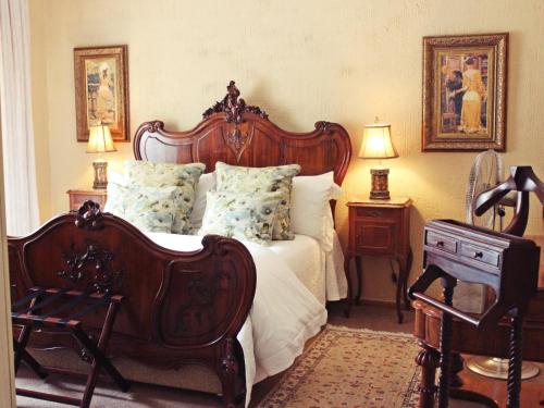 a bedroom with a large bed with a wooden headboard at Victorian Manor Guesthouse in Frankfort